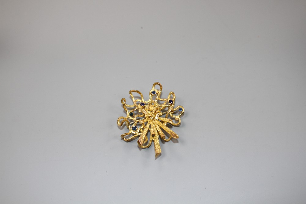 A 1970s? unmarked yellow metal and six stone sapphire set modernist scroll brooch, 46mm, gross weight 17.5 grams.